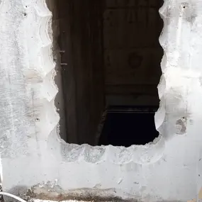 Wanddurchbruch in Beton mit freigelegter Öffnung, Bauarbeiten und Bauschutt