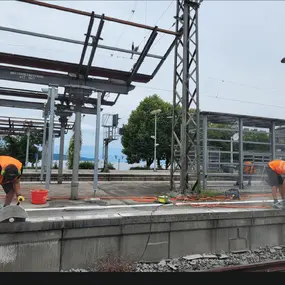 Bauarbeiter schneiden Bahnsteigkante am Bahnhof, Gleisbau mit Trennschleifer