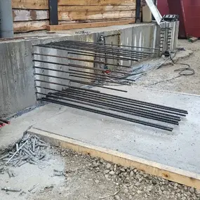 Baustelle mit Betonwand, herausragender Bewehrung und Holzschalung im Wald