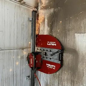 Hilti Wandsäge schneidet Betonwand, Funkenflug beim Betonschneiden.