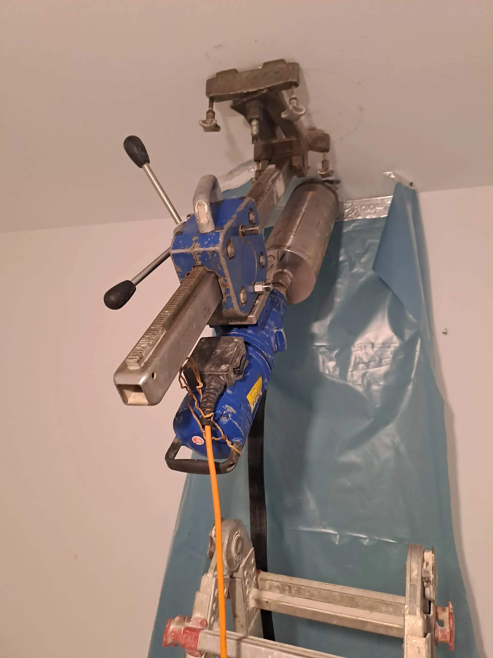 Blauer Rohrschneider mit Klemmen an Decke, Baustelle Innenausbau￼